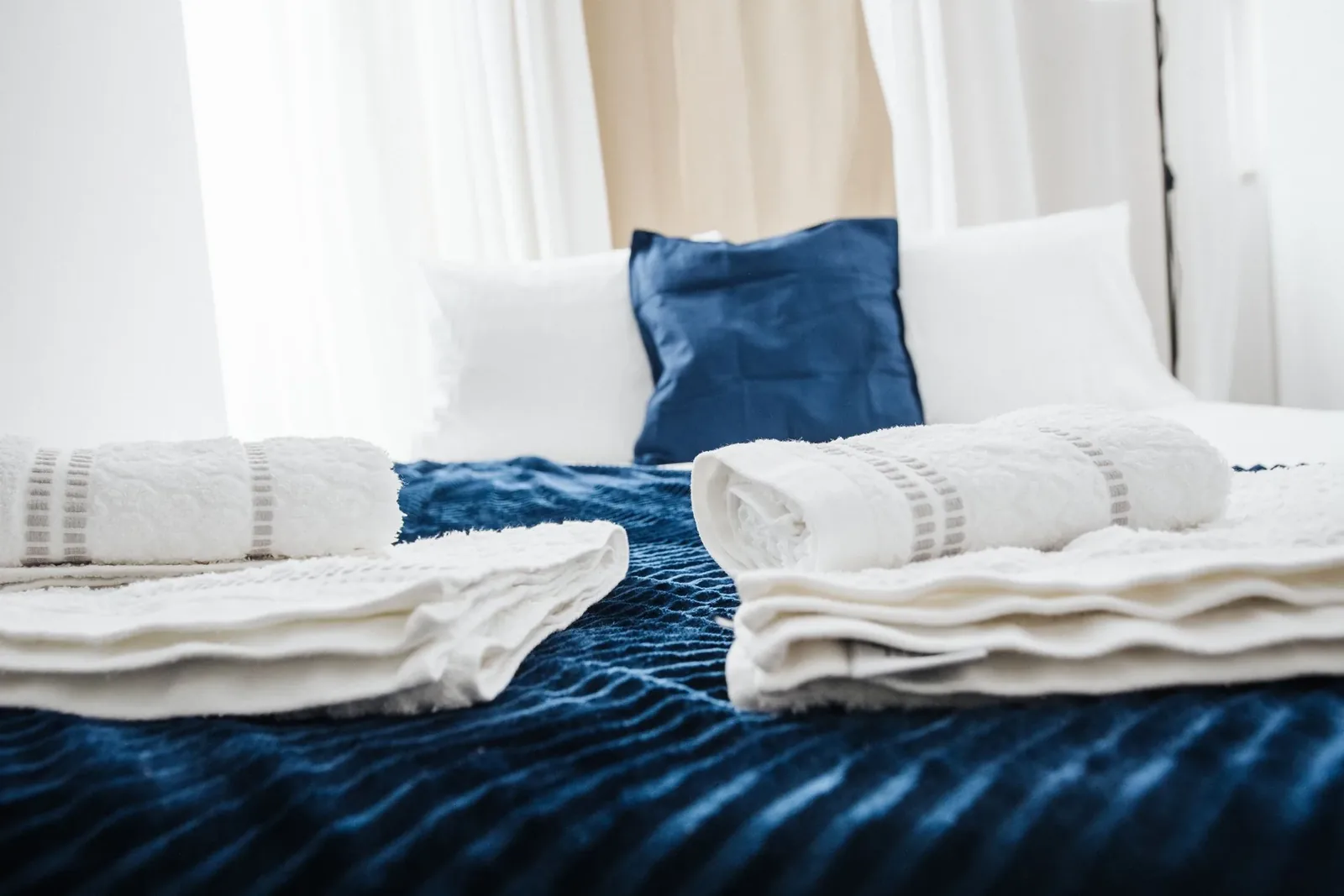 Bright bedroom with a made bed and neatly arranged towels