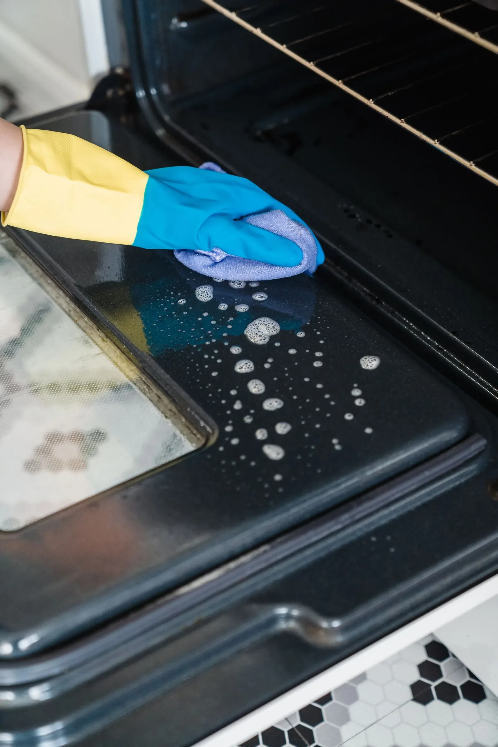 Close-up of manually cleaning the inside of an oven